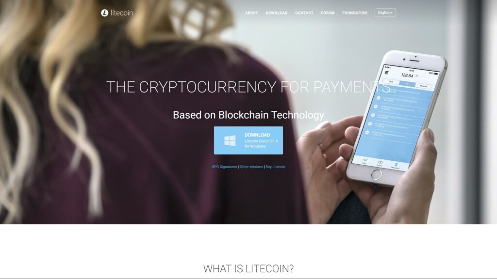 Homepage of the official Litecoin website featuring the headline 'THE CRYPTOCURRENCY FOR PAYMENTS' and 'Based on Blockchain Technology.' The visual displays a person holding a smartphone with a Litecoin wallet app showing a balance and transaction history. A prominent blue button offers a download for 'Litecoin Core 0.21.4 for Windows,' and the top navigation includes links for About, Download, Forum, and Foundation