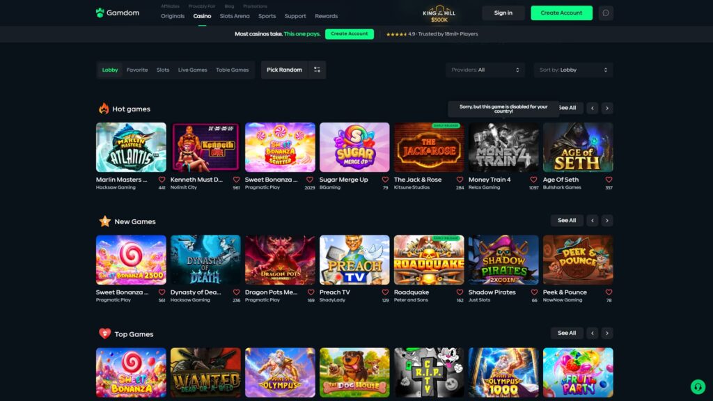 Gamdom crypto casino Casino lobby page displaying the King of the Hill $500K promotional banner in the top centre of the dark-themed header alongside the green Gamdom logo, primary navigation tabs for Originals, Casino (active with green underline), Slots Arena, Sports, Support and Rewards, secondary header links for Affiliates, Provably Fair, Blog and Promotions, prominent green call-to-action ribbon stating 'Most casinos take. This one pays.' with a Create Account button alongside a 4.9-star rating from '18mil+ Players' trust signal, sub-navigation with Lobby (active), Favorite, Slots, Live Games, Table Games, Pick Random and a filter button, Providers and Sort By dropdown filters set to All and Lobby, Hot Games row featuring seven slot thumbnails — Marlin Masters Atlantis by Hacksaw Gaming (441 likes), Kenneth Must Die by Nolimit City (961), Sweet Bonanza Super Scatter by Pragmatic Play (2,029), Sugar Merge Up by BGaming (79), The Jack & Rose Early Release by Kitsune Studios (284), Money Train 4 by Relax Gaming (1,097) and Age Of Seth by Bullshark Games (357) — overlapping 'Sorry, but this game is disabled for your country!' geo-restriction error tooltip, New Games row showing Sweet Bonanza 2500 by Pragmatic Play (561), Dynasty of Death by Hacksaw Gaming (236), Dragon Pots Megaways by Pragmatic Play (169), Preach TV by ShadyLady (129), Roadquake Early Release by Peter and Sons (162), Shadow Pirates 2xCoin by Just Slots (66) and Peek & Pounce by NowNow Gaming (78), beginning of a Top Games section showing Sweet Bonanza, Wanted Dead or A Wild, Gates of Olympus, The Dog House, R.I.P. CTV, Gates of Olympus 1000 and Fruit Party thumbnails, plus Sign In and green Create Account CTAs in the top-right corner