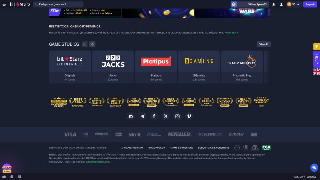 BitStarz online crypto casino footer page section displaying the lower portion of a slot game promotional banner row at the top showing a 'NEW GAME' card with bet limits $0.20–$50, High volatility, 5,000x multiplier and Belatra game studio details, plus partial views of two additional purple-themed promotional cards, 'BEST BITCOIN CASINO EXPERIENCE' editorial heading with introductory copy promoting Bitcoin's role as the foremost cryptocurrency accepted by hundreds of thousands of businesses and a green 'Read more' link, Game Studios carousel showcasing five provider tiles in dark cards including BitStarz Originals (14 games), Jacks (22 games), Platipus (180 games), BGaming (236 games) and Pragmatic Play (586 games) with a View All button and pagination arrows, comprehensive trust and award badge row featuring 12 industry recognition seals including Casinomeister Accredited Casino, Best Casino WoW 2025, Best Crypto Casino WoW 2025, Best Crypto Casino WoW 2024, Best Casino 2023 LCB Awards, Best Casino of 2022 AskGamblers, Best Support 2022 Casinomeister, Best Casino 2021 LCB Awards, Best Casino 2022 Casinomeister, Player's Choice Of 2018 AskGamblers, Best Casino Of 2017 AskGamblers, and Excellent Support LiveChat, social media icon row with Discord, Telegram, Facebook, X (Twitter), Instagram and Vimeo links, payment method logos including Visa, Mastercard, Bitcoin, Maestro, Skrill, Identity Verification, Neteller, Paysafecard, Zimpler and iDeb, copyright notice '© 2014-2026 BitStarz. All Rights Reserved' alongside footer links Affiliate Program, Privacy Policy, Terms & Conditions and Bonus Terms & Conditions plus regulatory icons for 18+, GamCare, Gaming Associates and CGA Curaçao Gaming Authority, detailed legal text noting BitStarz is operated by Gareton B.V. registered under No. 160656 at Landhuis Zuikertuin, Curaçao with licence number OGL/2024/165/0185 and contact email support@bitstarz.com, JackPotz Claim animated promo widget bottom-left, blue chat support bubble