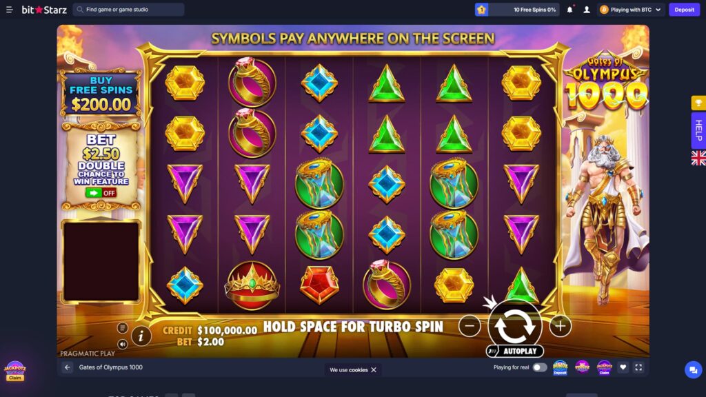 BitStarz online crypto casino playing the Gates of Olympus 1000 slot game by Pragmatic Play in immersive full-screen mode, featuring a 6-reel by 5-row purple gemstone-themed grid with 'SYMBOLS PAY ANYWHERE ON THE SCREEN' tagline displayed at the top, an active board populated with hexagonal yellow gems, pink ruby ring symbols, blue diamond gems, green triangle emeralds, purple inverted triangles, hourglass time-turner symbols, golden crowns and a red pentagon ruby, the imposing white-bearded Zeus character standing on the right side of the reels in golden armour with white robes against a sunset Greek temple backdrop, prominent left-side bonus widgets including a 'BUY FREE SPINS $200.00' purple banner offering instant entry to the bonus round and a parchment scroll promoting the 'BET $2.50 DOUBLE CHANCE TO WIN FEATURE' currently toggled OFF, golden ornate frame surrounding the reel area with stone column pillars and flame torches on either side, gameplay info bar at the bottom showing CREDIT $100,000.00 alongside BET $2.00, 'HOLD SPACE FOR TURBO SPIN' instruction, central white circular Spin button with smaller minus and plus bet adjustment buttons and an AUTOPLAY trigger, vertical Gates of Olympus 1000 logo with golden 1000 numerals on the right, top header showing player rank 1 badge with '10 Free Spins 0%' progress widget, notification bell, profile icon, BTC wallet labelled 'Playing with BTC' and a purple Deposit button, JackPotz Claim animated promo widget bottom-left, vertical yellow trophy and HELP buttons plus UK flag region selector on the right edge, info icon and game title 'Gates of Olympus 1000' at the bottom-left, 'Playing for real' toggle, Bonuz Mania Deposit, Piggyz, Jackpotz and favourite icons, plus a fullscreen toggle in the bottom-right
